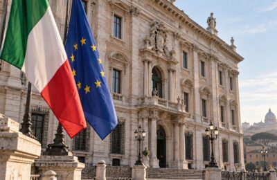 Bandiere italiana ed europea davanti a un palazzo istituzionale di Roma